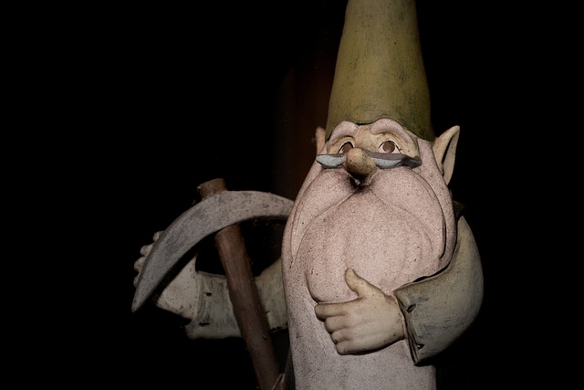 Older, full white bearded garden gnome wearing halg glasses and holding a pick axe